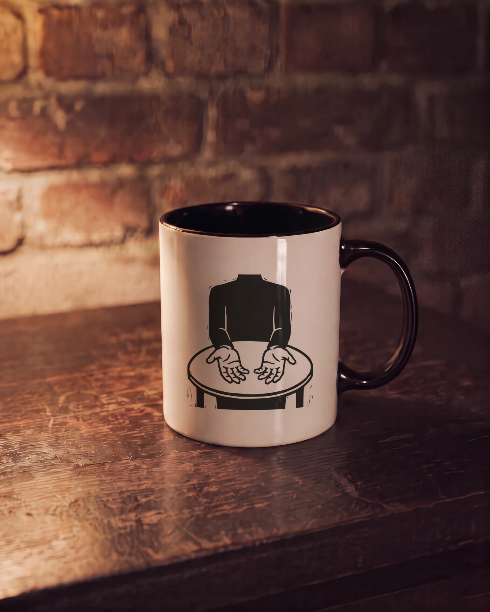 A white mug with a black inside and handle on a wooden table, the Sapien mark printed on its side